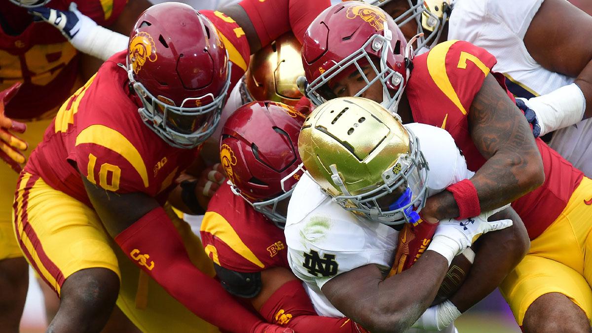 Notre Dame Fighting Irish running back Jeremiyah Love (4) is stopped by the Southern California Trojans defense during the first half at the Los Angeles Memorial Coliseum.