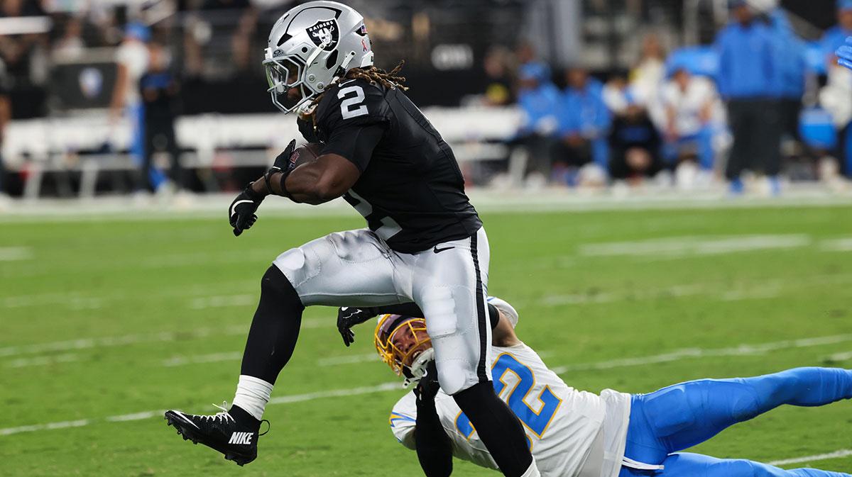 Las Vegas Raiders running back Ashton Jeanty (2) evades a tackle from Los Angeles Chargers safety Alohi Gilman (32) during the first quarter at Allegiant Stadium.