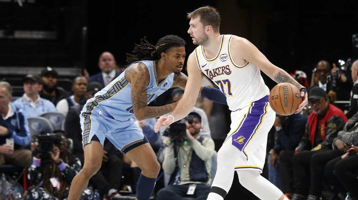 Los Angeles Lakers guard Luka Doncic (77) dribbles as Memphis Grizzlies guard Ja Morant (12) defends during the third quarter at FedExForum.