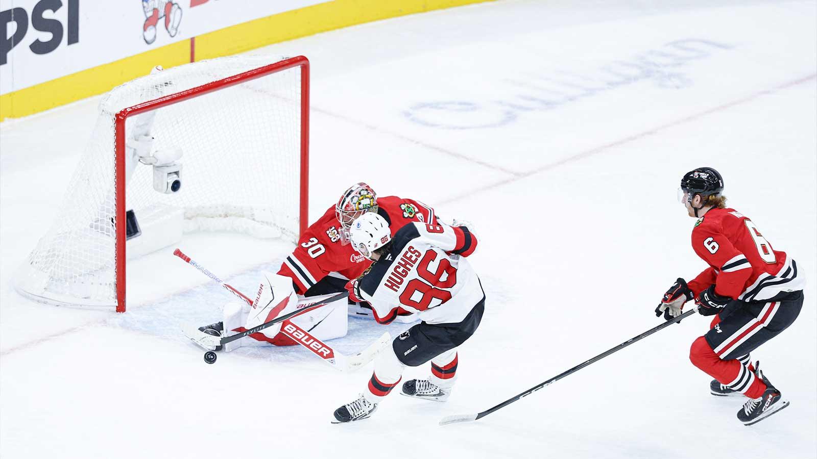 Chicago Blackhawks goaltender Spencer Knight (30) defends against New Jersey Devils center Jack Hughes (86) during the second period at United Center.