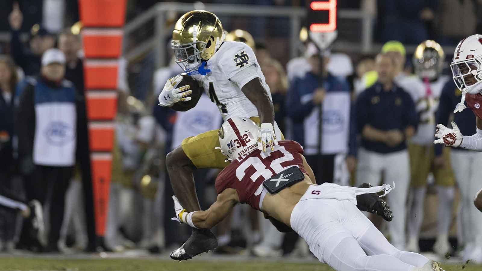 Notre Dame Fighting Irish running back Jeremiyah Love (4) attempts to run past Stanford Cardinal safety Mitch Leigber (32) during the first quarter at Stanford Stadium.
