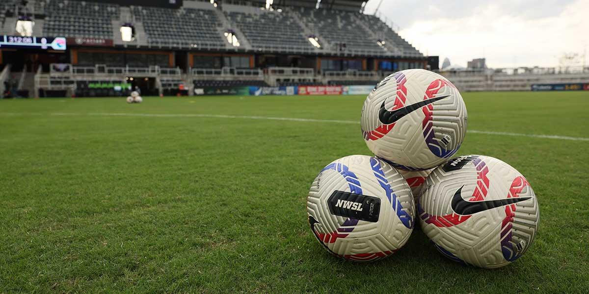 National Womens Soccer League (NWSL) soccer balls are seen on the field prior to a match between San Diego Wave FC and Racing Louisville FC at Lynn Family Stadium.