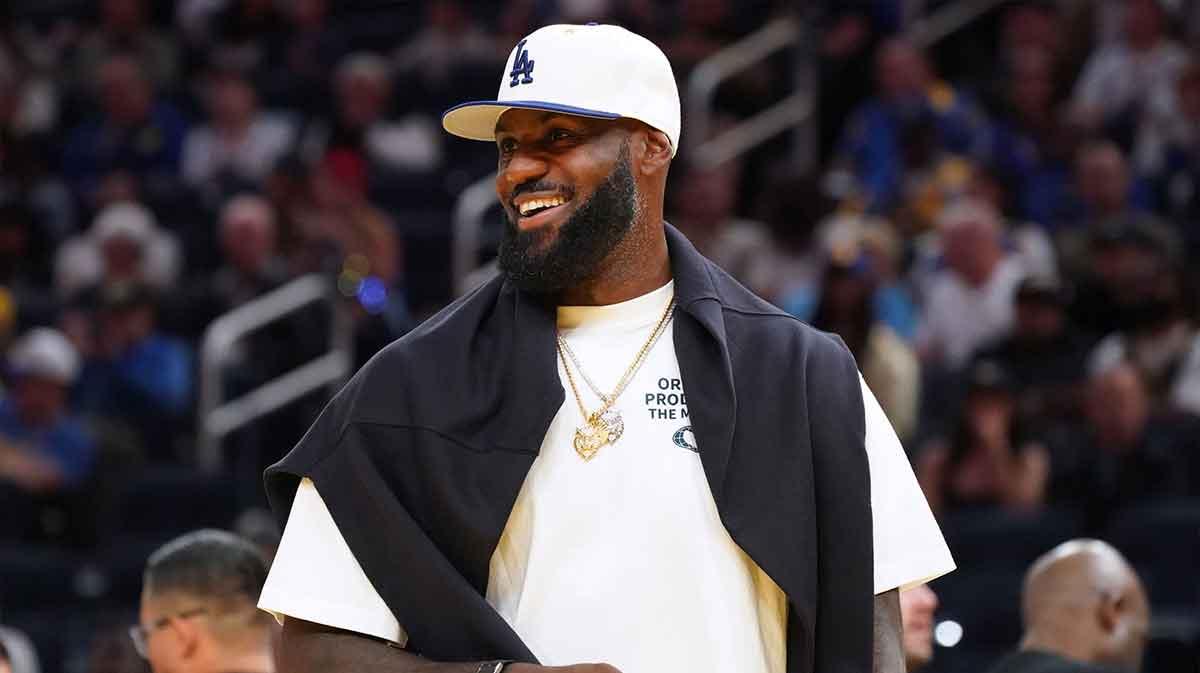 Los Angeles Lakers forward LeBron James (23), wearing a Los Angeles Dodgers hat, watches from the sideline during a break against the Golden State Warriors in the third quarter at Chase Center.