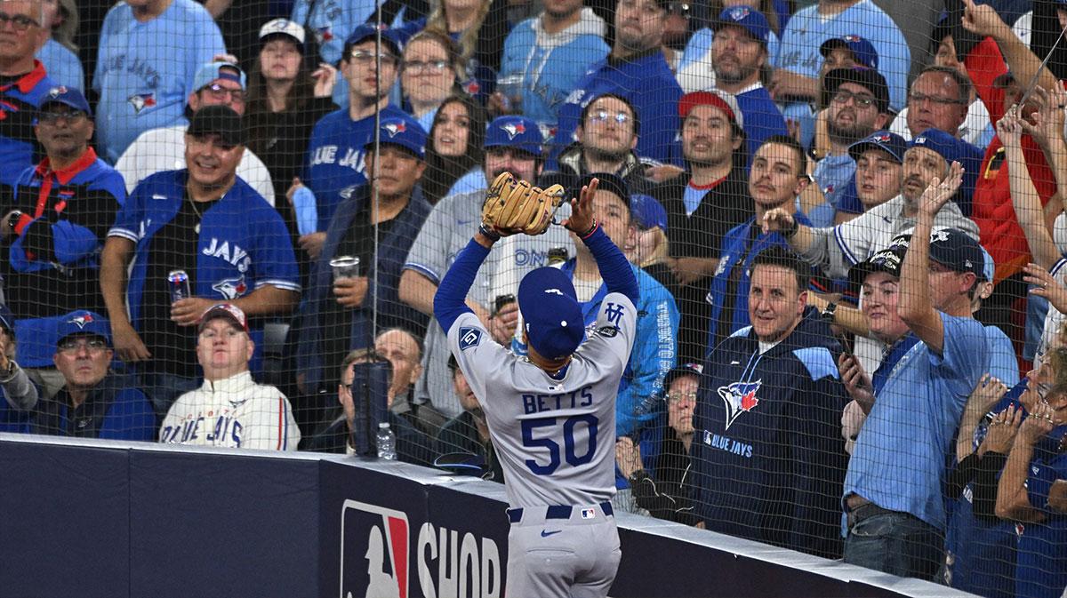 Los Angeles Dodgers shortstop Mookie Betts (50) makes a catch against Toronto Blue Jays designated hitter Bo Bichette (11) in the eighth inning during game six of the 2025 MLB World Series at Rogers Centre. Mandatory Credit: Dan Hamilton-Imagn Images