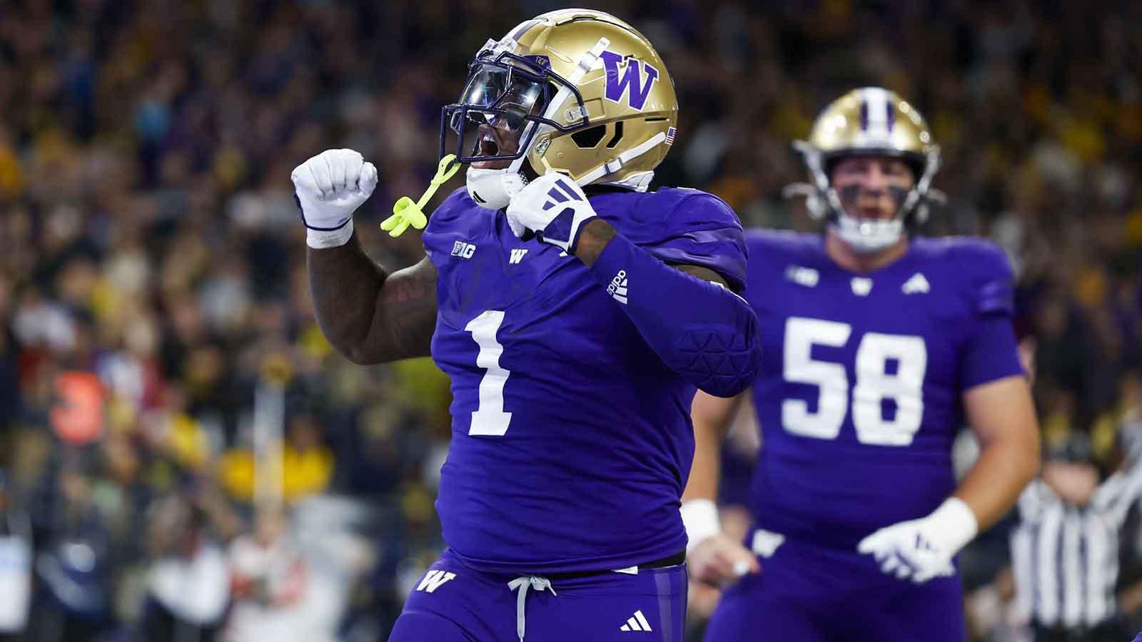 Washington Huskies running back Jonah Coleman (1) celebrates after rushing for a touchdown against the Michigan Wolverines during the fourth quarter at Alaska Airlines Field at Husky Stadium.