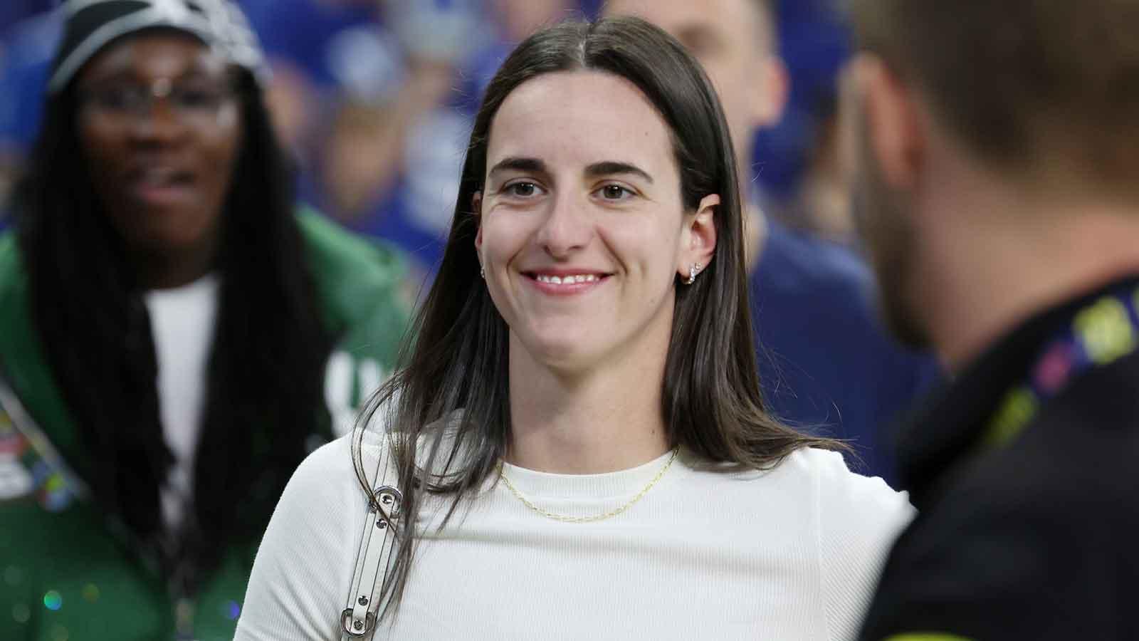 Caitlin Clark looks on from the sideline during warmups before the game between the Las Vegas Raiders and the Indianapolis Colts at Lucas Oil Stadium.