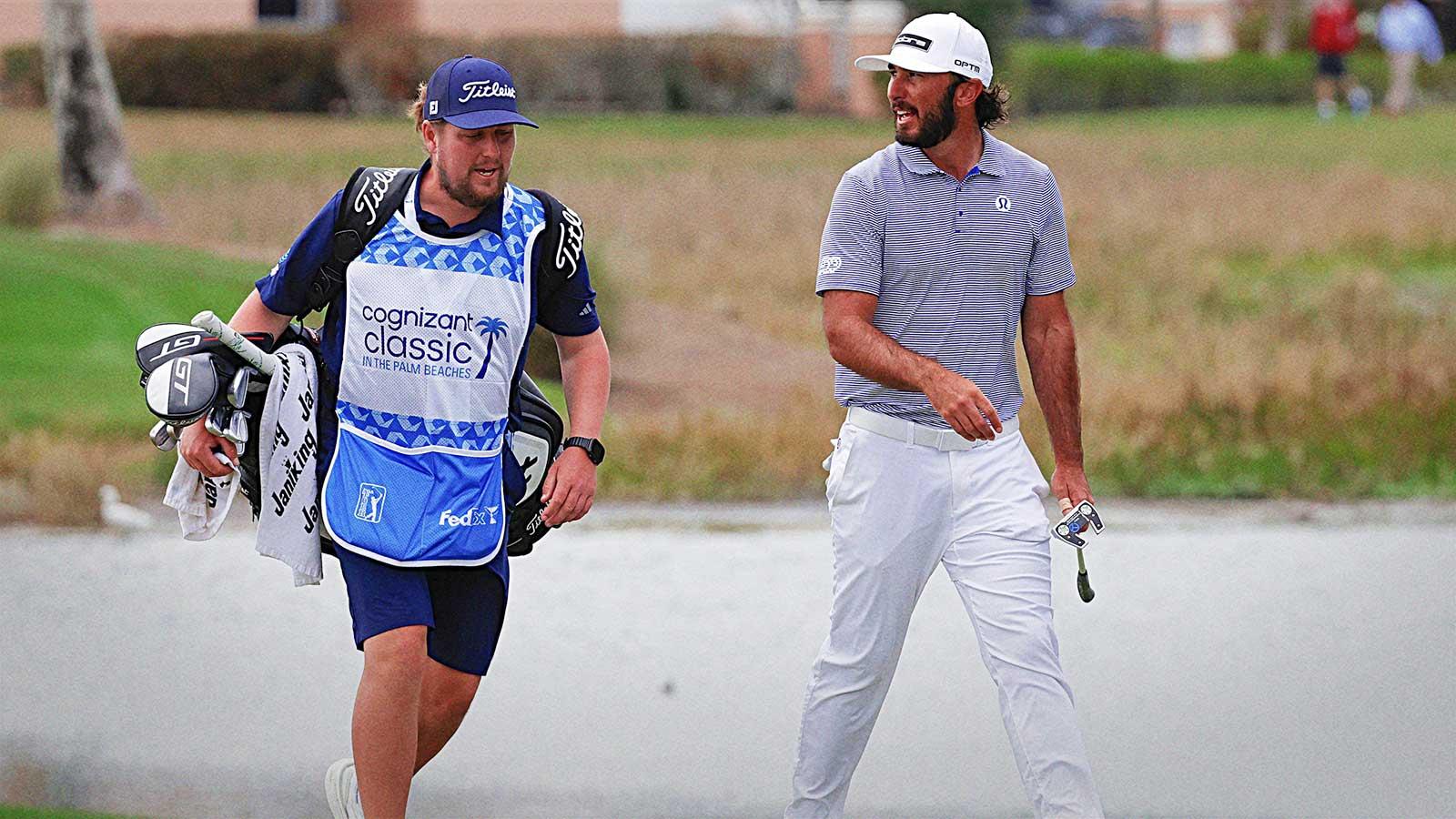 Max Homa (right) walks up to the eighth green with his caddie during the first round of the Cognizant Classic golf tournament.