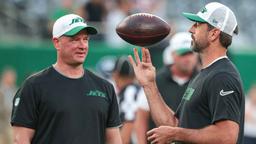 New York Jets quarterback Aaron Rodgers (left) spins the ball in front of offensive coordinator Nathaniel Hackett before the game against the New York Giants at MetLife Stadium.